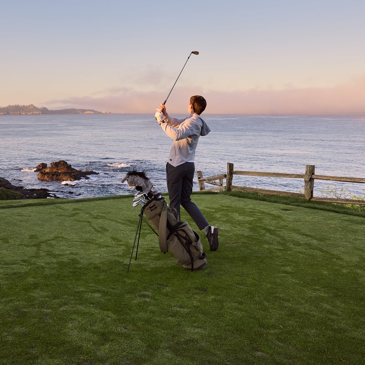Person playing golf on a scenic golf course with ocean view