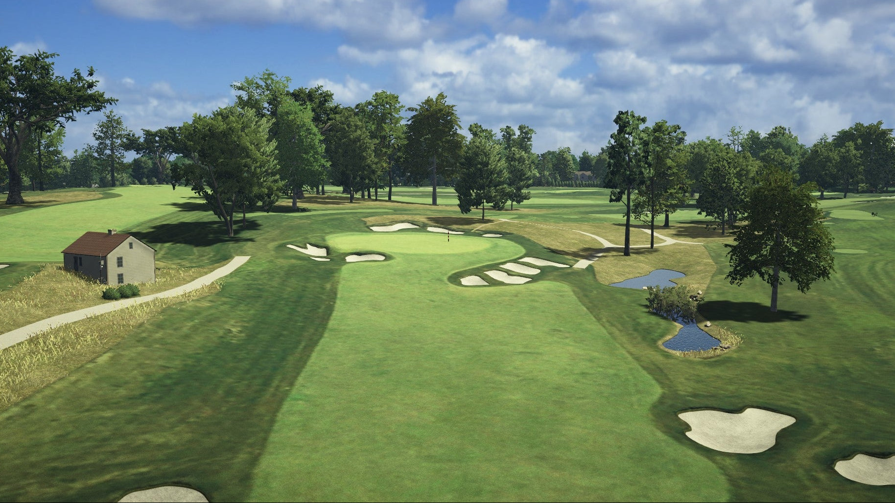 Golf course with green grass, trees, and a clear sky.
